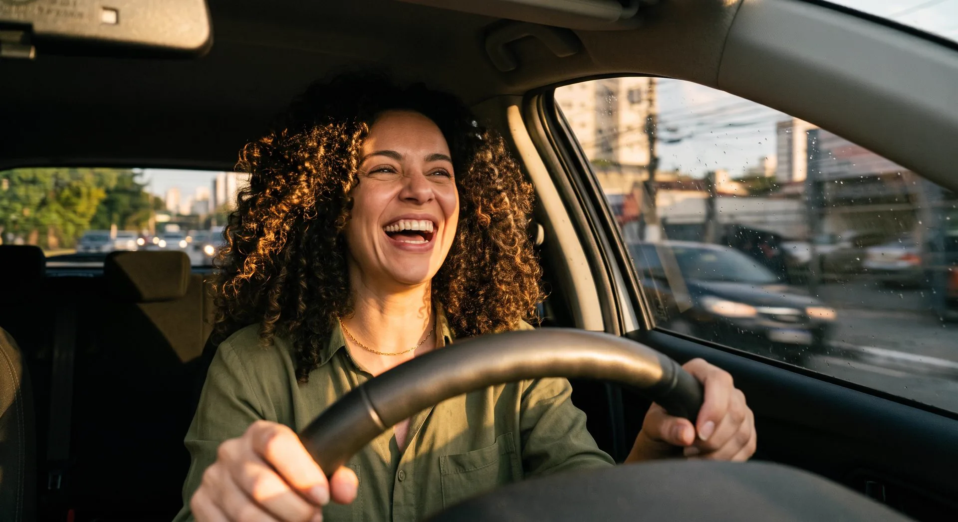 Mulher sorrindo ao volante de um carro segurado pela Bet Seguros